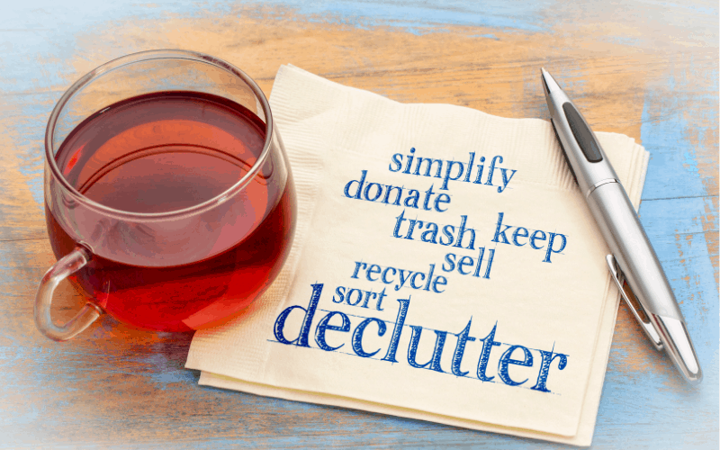 cup of tea and these words written on a napkin: simplify donate trash keep sell recycle sort declutter.