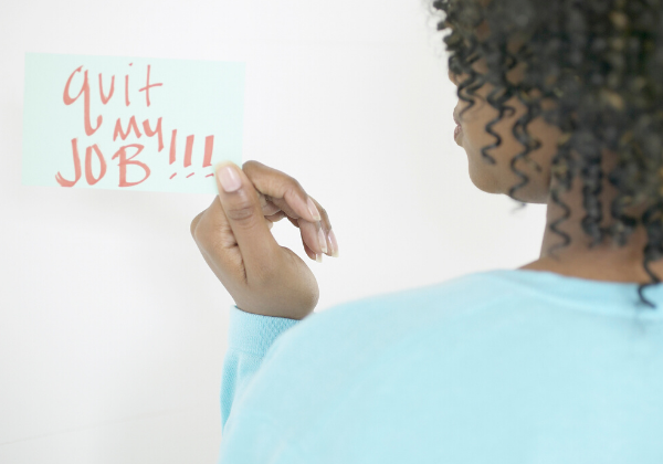 Woman holding sticky that says "Quit my job!!!"