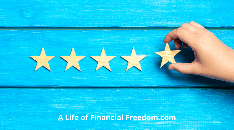 Hand placing 5 stars on a blue background. A life of financial freedom.com.