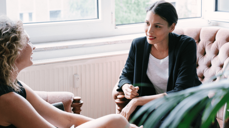 Two women talking. One is a life coach talking with her client.