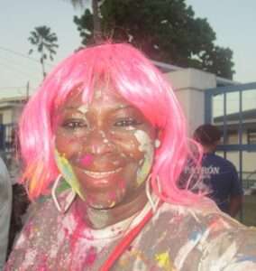 Woman in pink wig during paint and mud celebration at Trinidad Carnival. 