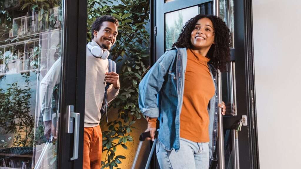 Couple walking into their Airbnb with rolling luggage. Article is 28 business ideas for the 2028 olympics in los angeles