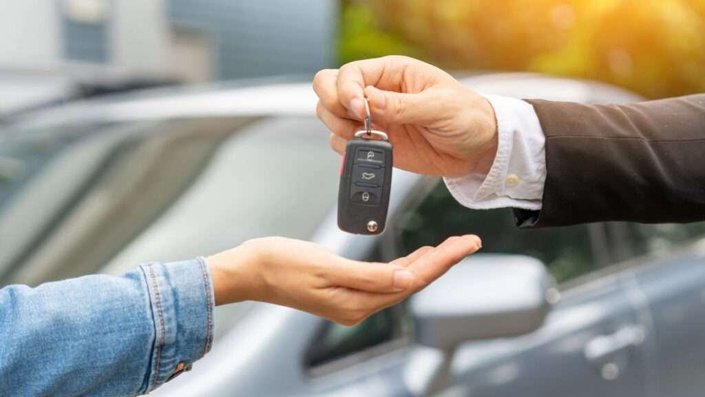 male car selling giving keys to woman